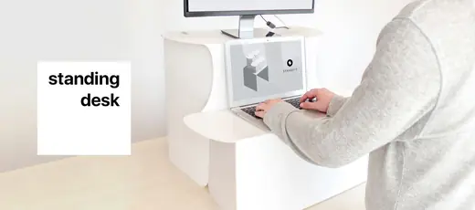 Standify standing desk on a table, a person typing on a laptop