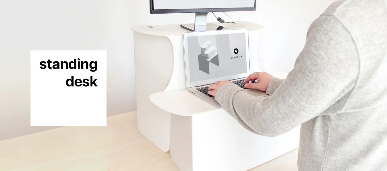 Standify standing desk on a table, a person typing on a laptop
