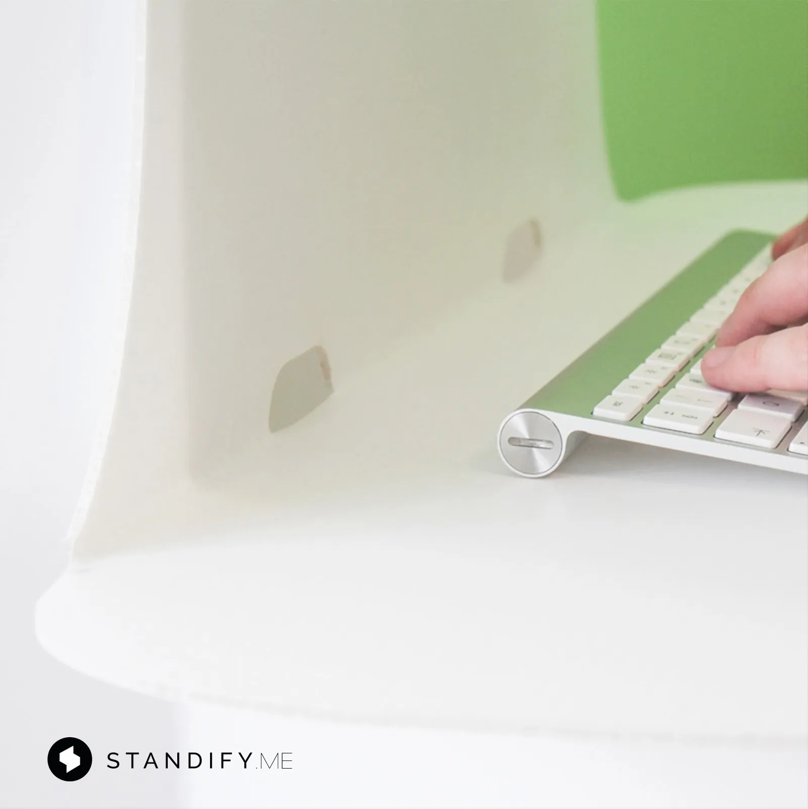 Close-up of a hand at a keyboard on the white Standify desk