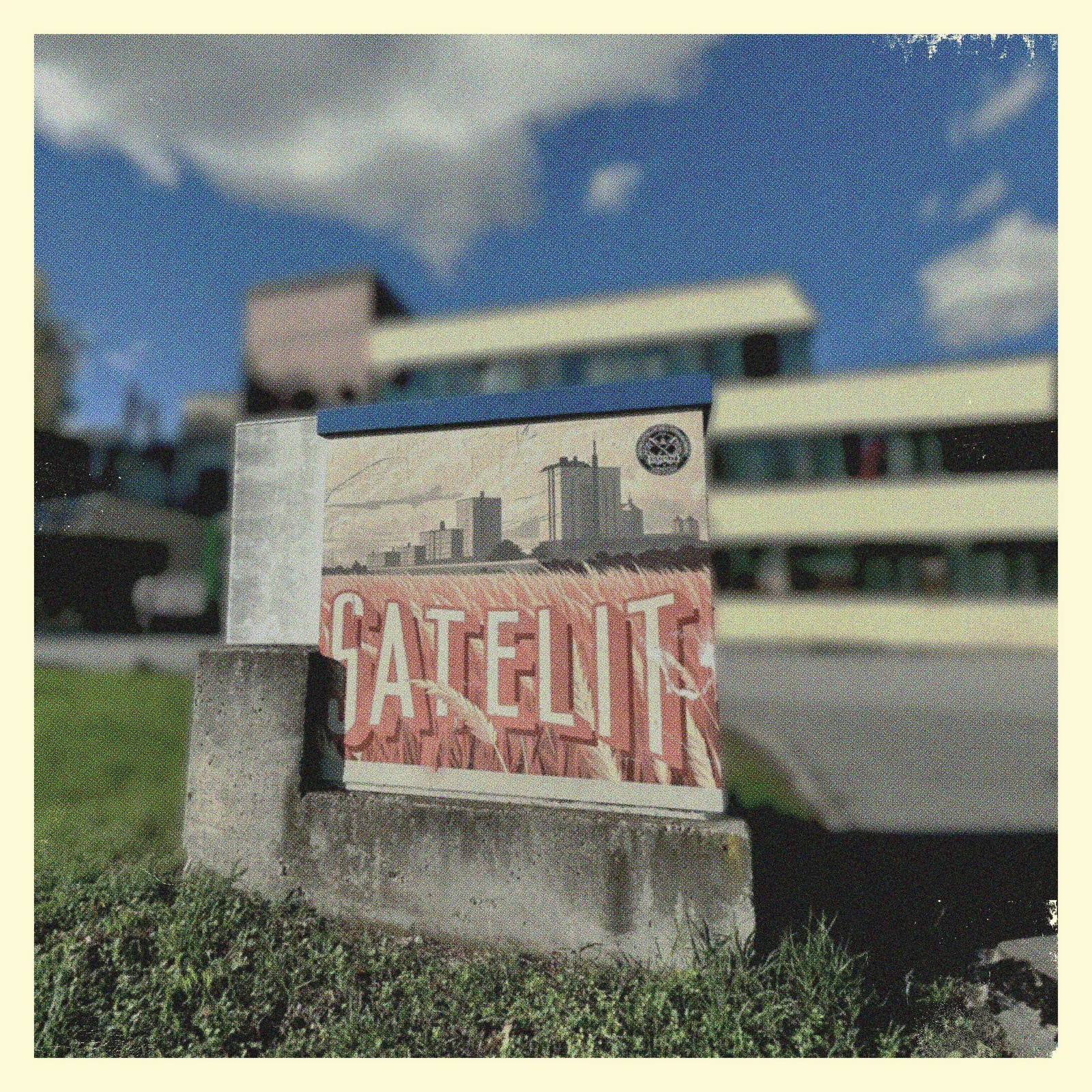 Neusatz: The Satelit poster pasted on a utility box in the street, Satelit tower blocks behind