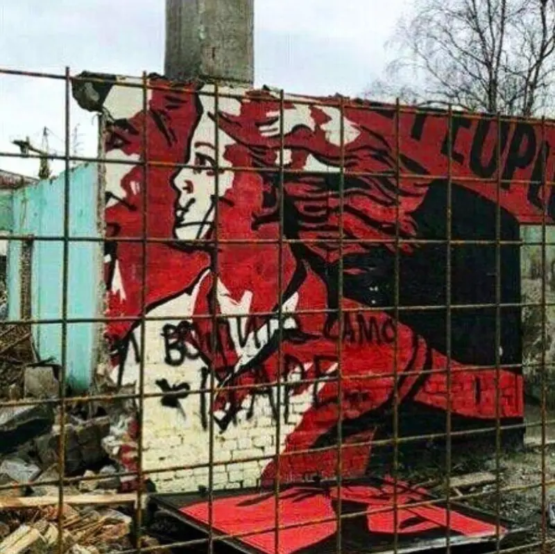 destroyed mural showing a face of a girl