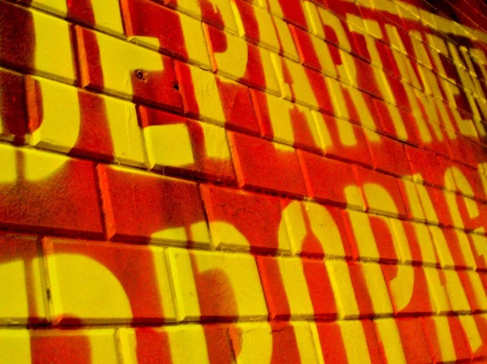 Propaganda Department: Close view of the yellow lettering on red bricks