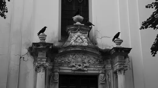 Crows on the church portal under the eye of providence