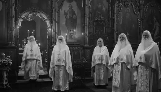 Five bearded priests in white before the iconostasis