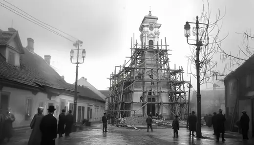 The church in scaffolding beyond gas lamps and passers-by