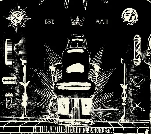Detail: the barber’s chair between candles, razors and combs, marked Est. MMIII
