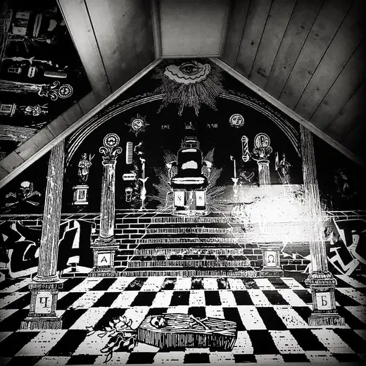 The mural on the barbershop’s sloping wall: a barber’s chair on a checkered floor under the eye of providence